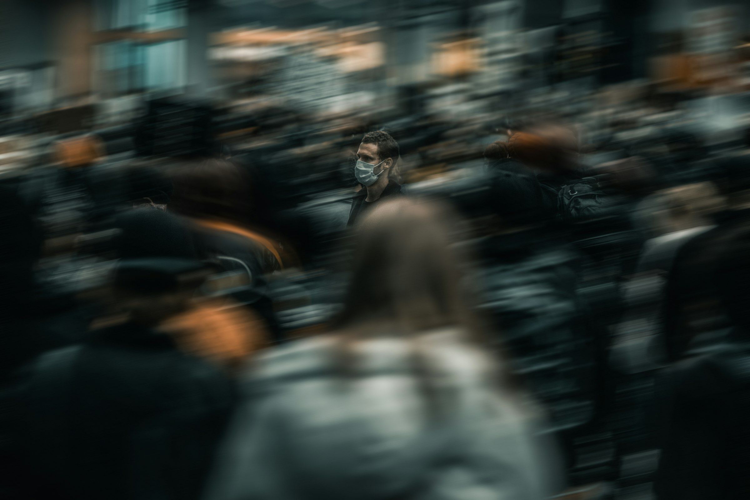 A busy crowd of people, blurred with movement.